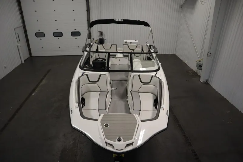 Slide: The Image of 2025 Yamaha Boats 250 SX in a showroom, showcasing sleek design and spacious seating. - 8