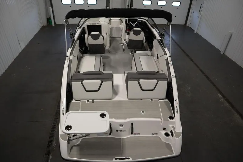 Slide: The Image of 2025 Yamaha Boats 250 SX interior with seating and table in a showroom. - 9