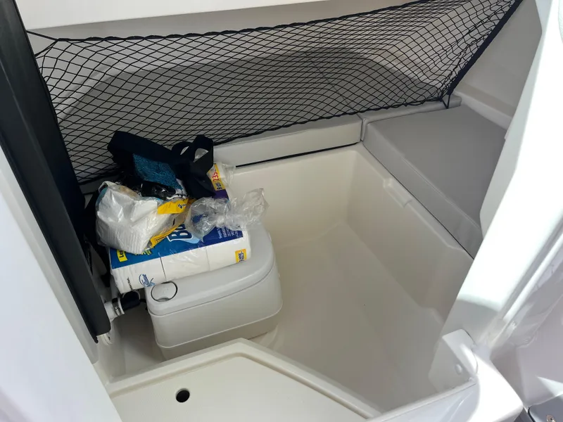 Slide: The Image of 2021 Sea Ray SDX 250 Outboard storage area with netting and supplies. - 7