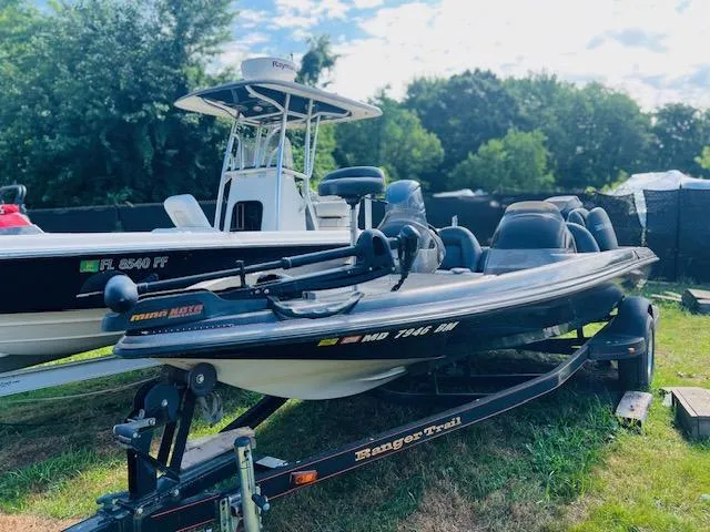 Slide: The Image of 2003 Ranger 195VS boat on trailer, parked on grass, with trees in background. - 0