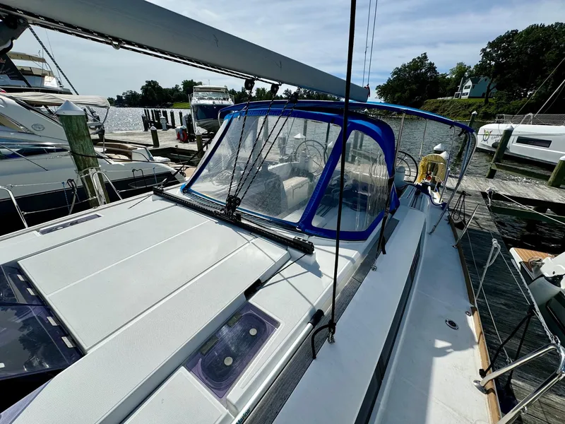 Slide: The Image of 2016 Jeanneau Sun Odyssey 479 sailboat docked at marina, featuring blue canopy. - 12