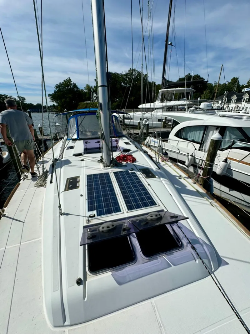Slide: The Image of 2016 Jeanneau Sun Odyssey 479 sailboat with solar panels, docked in a marina. - 13
