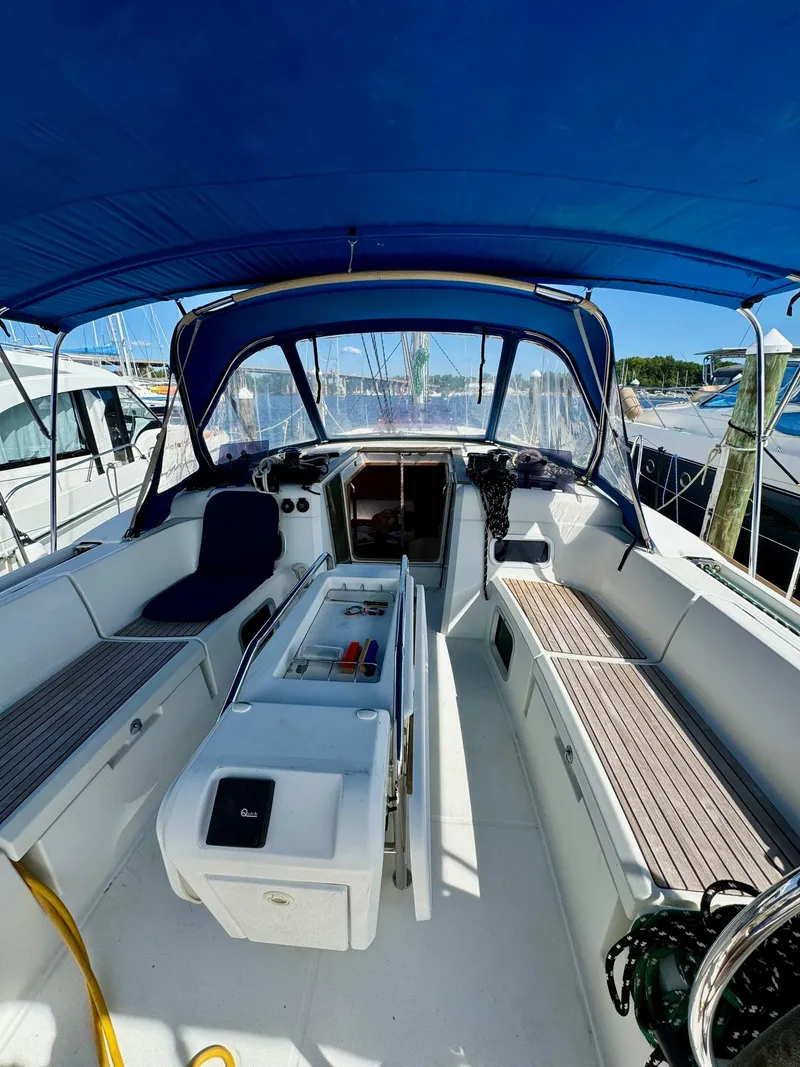 Slide: The Image of 2016 Jeanneau Sun Odyssey 479 sailboat cockpit with blue canopy, docked at marina. - 14