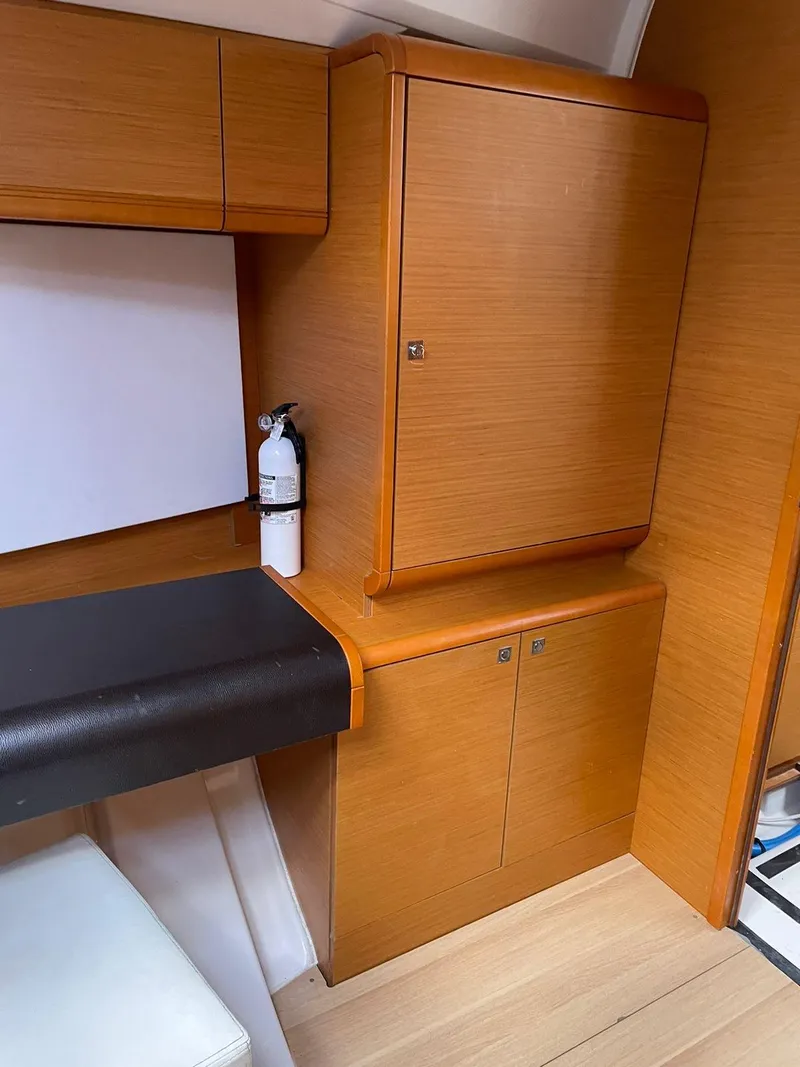Slide: The Image of Interior of 2016 Jeanneau Sun Odyssey 479 with wooden cabinetry and fire extinguisher. - 19