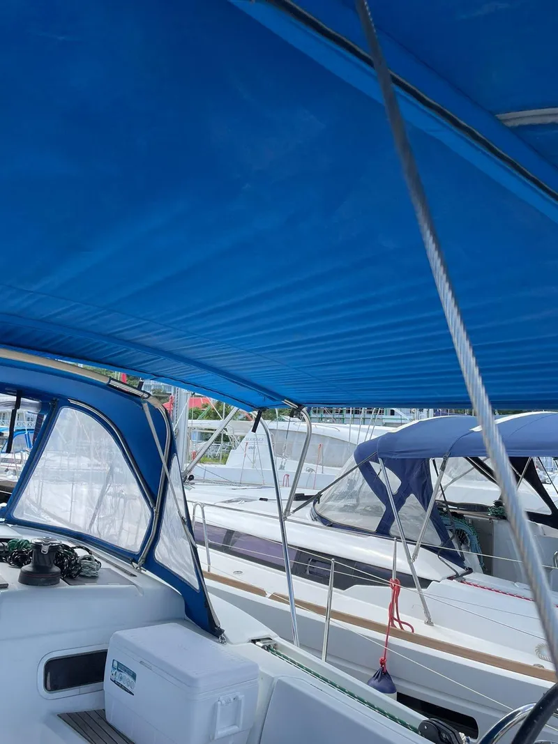 Slide: The Image of Jeanneau Sun Odyssey 479 sailboat, 2016 model, with blue canopy in marina setting. - 34