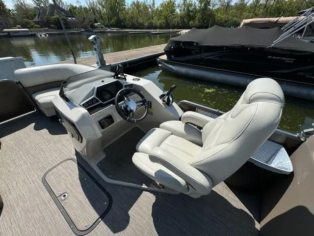 Slide: The Image of 2021 Manitou RF 23 Oasis VP boat interior with steering wheel and plush seating. - 12