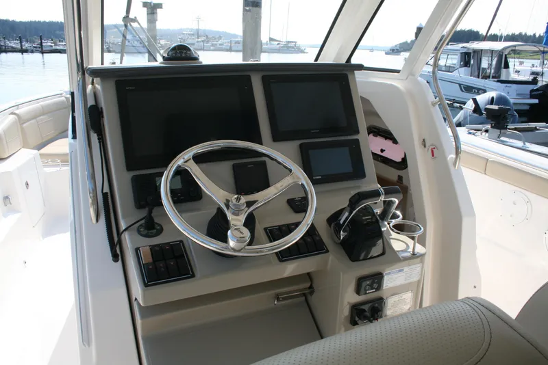 Slide: The Image of 2018 Pursuit S 328 Sport boat dashboard with steering wheel and navigation screens. - 14