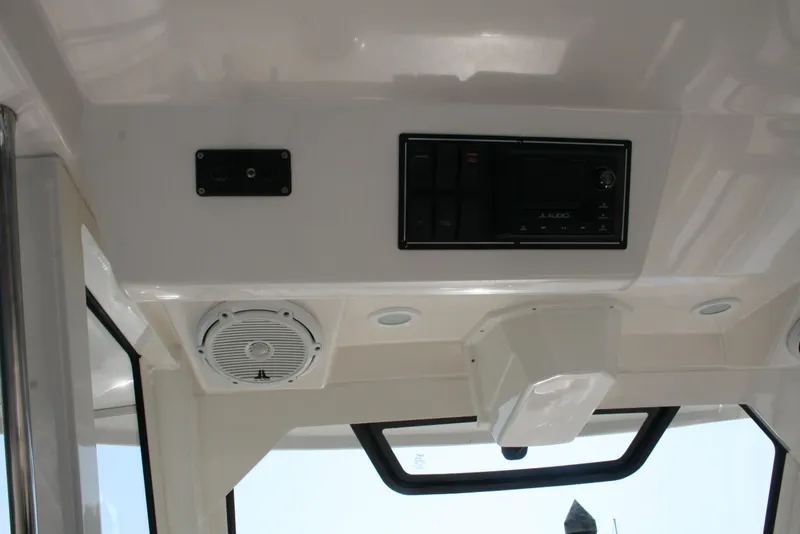 Slide: The Image of Interior view of 2018 Pursuit S 328 Sport boat, featuring control panel and speaker. - 15