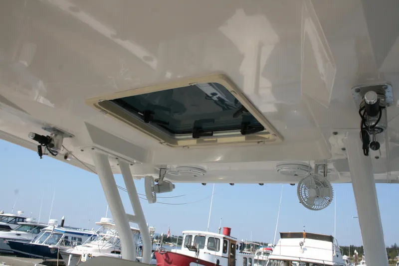 Slide: The Image of 2018 Pursuit S 328 Sport boat interior with open hatch and docked boats in background. - 16