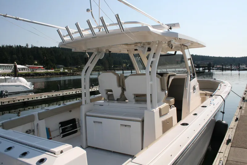 Slide: The Image of 2018 Pursuit S 328 Sport boat docked at marina, showcasing spacious deck and seating. - 2