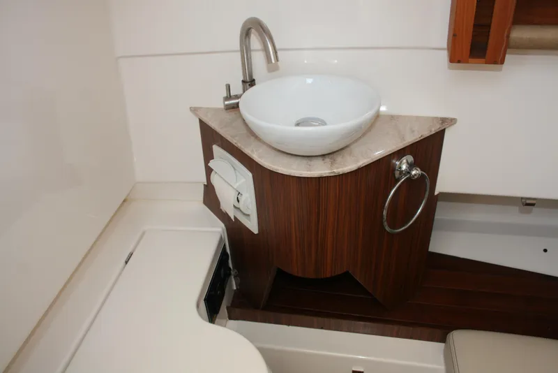 Slide: The Image of 2018 Pursuit S 328 Sport boat bathroom with modern sink and wooden cabinetry. - 20