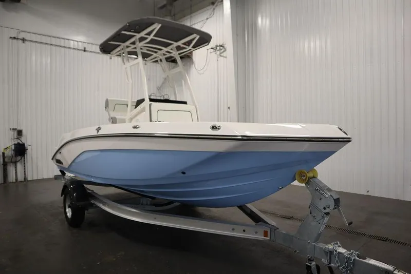 The Image of 2025 Yamaha Boats 190 FSH Sport in a showroom, featuring a sleek blue hull design. - 0