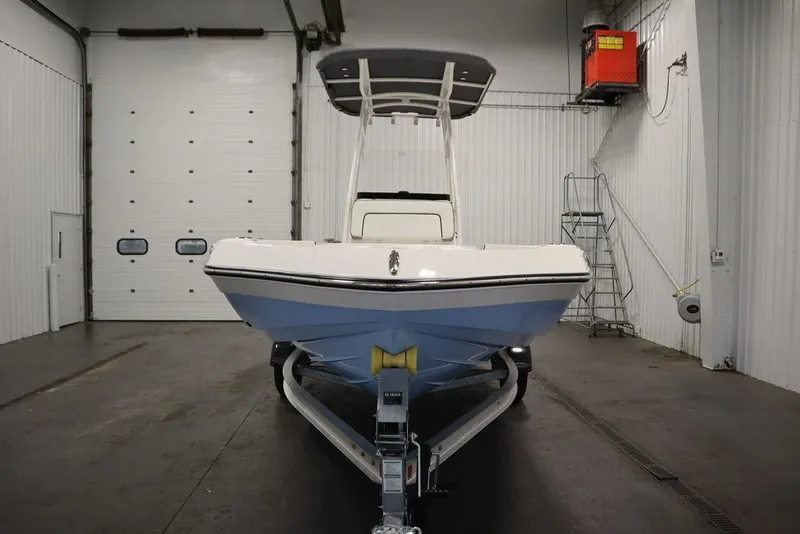 Slide: The Image of 2025 Yamaha Boats 190 FSH Sport in a garage, front view on trailer. - 1
