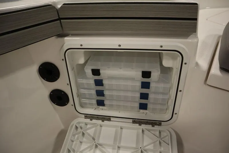 Slide: The Image of Yamaha Boats 2025 190 FSH Sport storage compartment with organized tackle boxes. - 18