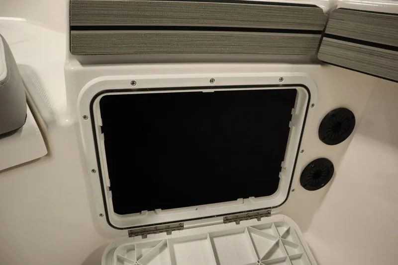 Slide: The Image of 2025 Yamaha Boats 190 FSH Sport storage compartment with speakers, open hatch. - 19