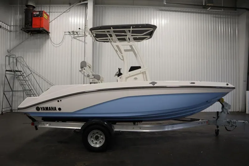 Slide: The Image of 2025 Yamaha Boats 190 FSH Sport in a showroom, side view. - 2