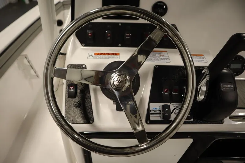 Slide: The Image of Steering wheel of 2025 Yamaha Boats 190 FSH Sport, featuring control panel and throttle. - 25