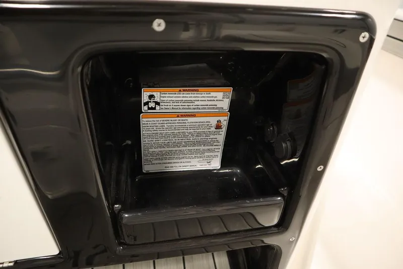 Slide: The Image of Yamaha Boats 2025 190 FSH Sport storage compartment with safety warning label. - 31