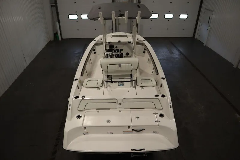 Slide: The Image of 2025 Yamaha Boats 190 FSH Sport in a garage, showcasing sleek design and spacious deck. - 8
