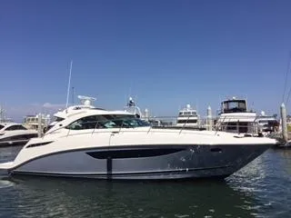 Slide: The Image of 2015 Sea Ray 410 Sundancer yacht docked in marina under clear blue sky. - 1