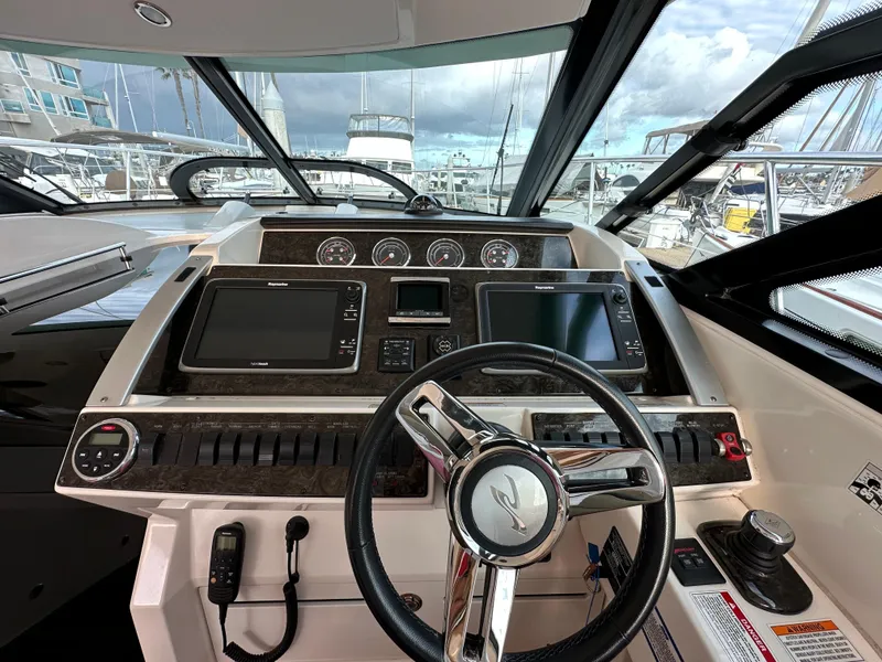 Slide: The Image of 2015 Sea Ray 410 Sundancer helm with modern navigation controls and steering wheel. - 10