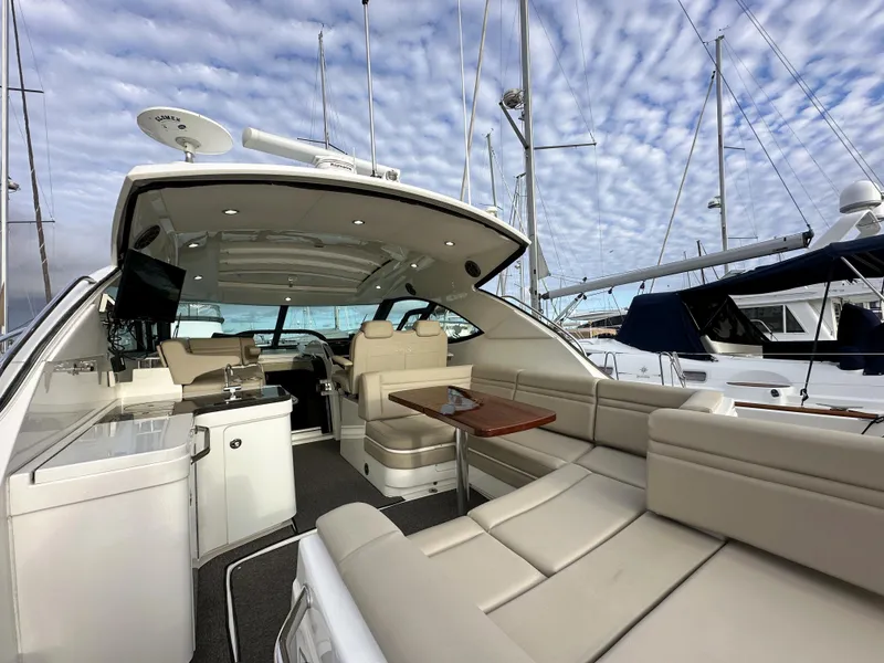 Slide: The Image of 2015 Sea Ray 410 Sundancer yacht with spacious seating and modern amenities in a marina. - 3