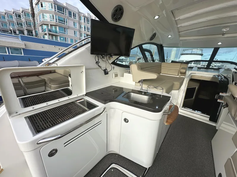 Slide: The Image of Luxurious 2015 Sea Ray 410 Sundancer yacht interior with kitchenette and seating area. - 5