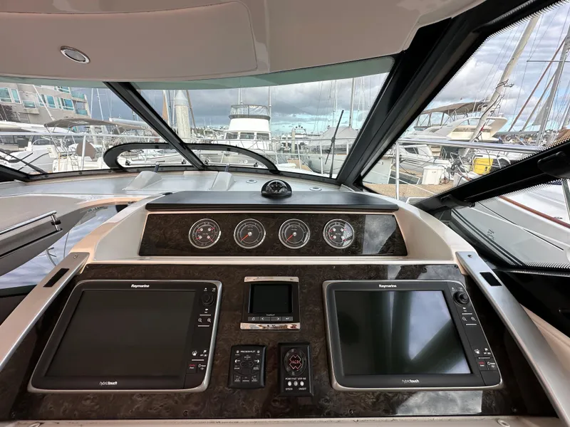 Slide: The Image of 2015 Sea Ray 410 Sundancer helm with navigation screens and gauges at marina. - 9