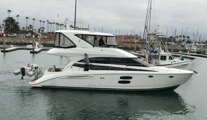 Slide: The Image of 2011 Meridian 441 Sedan Bridge yacht in marina, overcast sky, palm trees in background. - 0