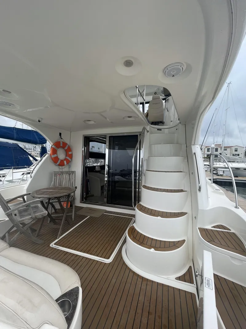 Slide: The Image of 2011 Meridian 441 Sedan Bridge yacht interior with wooden deck and spiral staircase. - 2