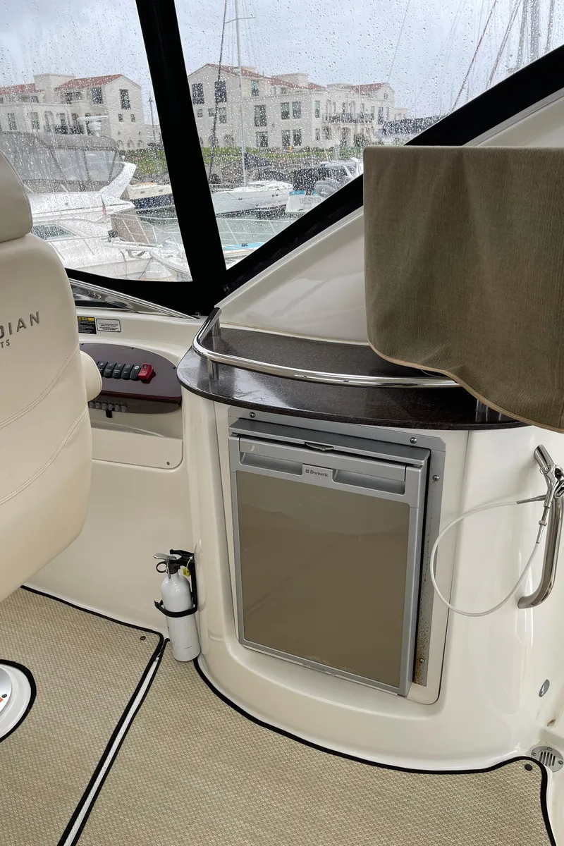 Slide: The Image of Interior of 2011 Meridian 441 Sedan Bridge yacht, featuring a compact fridge and seating area. - 23