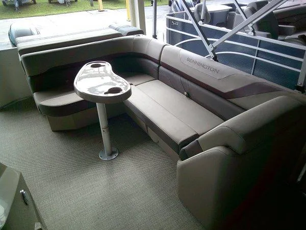 Slide: The Image of 2024 Bennington 20SLX pontoon boat interior with plush seating and table. - 4