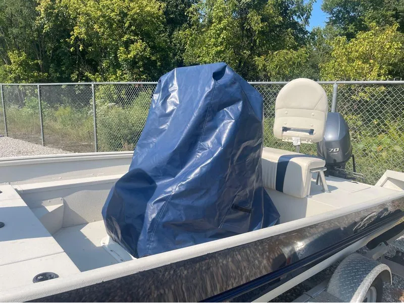 Slide: The Image of 2021 G3 Bay 17 boat with blue cover, parked outdoors near a fence. - 21