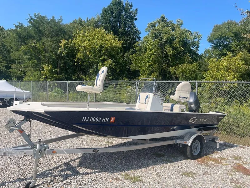Slide: The Image of 2021 G3 Bay 17 boat on trailer, parked outdoors with trees in background. - 22
