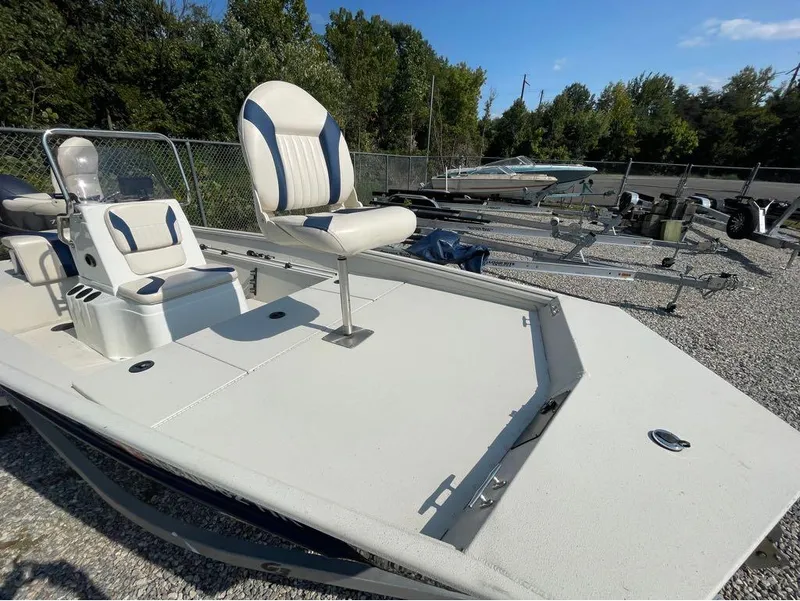 Slide: The Image of 2021 G3 Bay 17 boat with seating, parked on gravel near trailers and trees. - 7