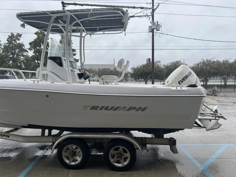 Slide: The Image of 2008 Triumph 215 CC boat on trailer with Evinrude outboard motor. - 10