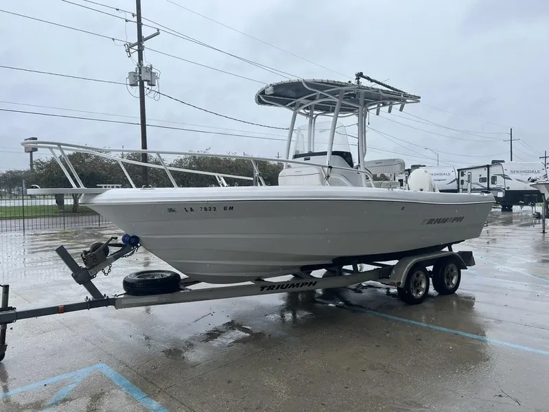 Slide: The Image of 2008 Triumph 215 CC boat on trailer in rainy parking lot. - 6