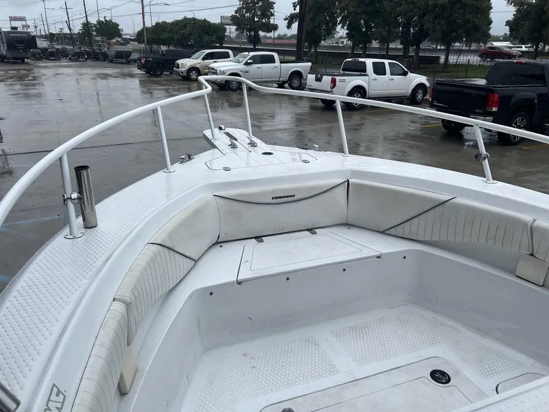 Slide: The Image of 2008 Triumph 215 CC boat interior with white seating, parked in a wet lot. - 8