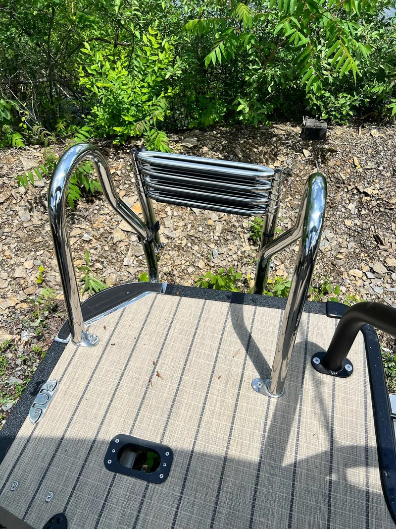 Slide: The Image of 2025 Sylvan L1 DLZ boat ladder on deck, surrounded by greenery. - 10