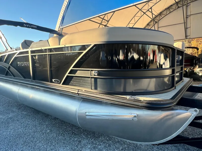 Slide: The Image of 2025 Sylvan L1 DLZ pontoon boat with sleek black design under a canopy. - 14