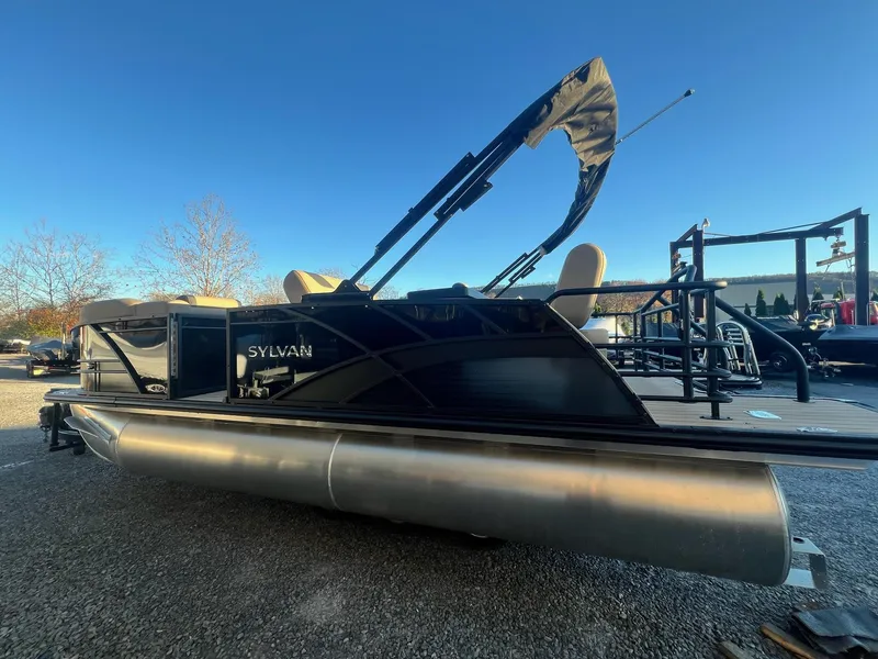 Slide: The Image of 2025 Sylvan L1 DLZ pontoon boat with canopy, parked outdoors. - 27