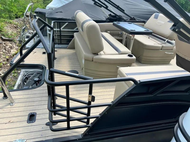 Slide: The Image of 2025 Sylvan L1 DLZ boat interior with beige seating and black railing. - 36