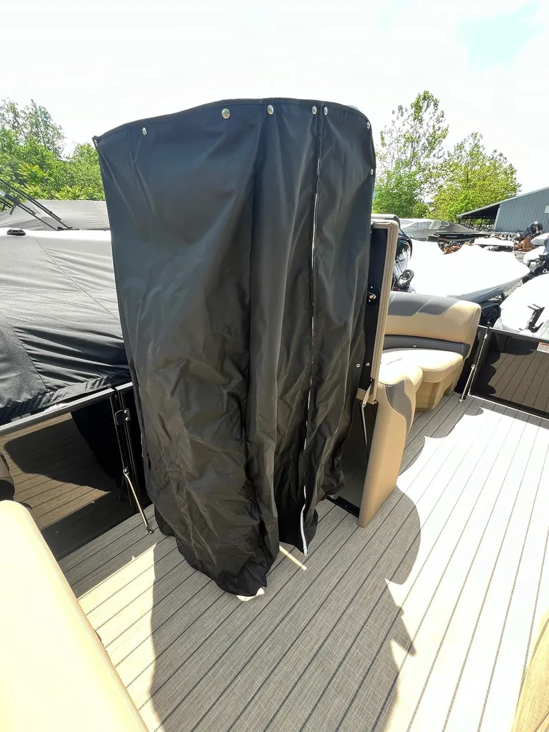 Slide: The Image of 2025 Sylvan L1 DLZ boat interior with black privacy curtain and beige seating. - 38