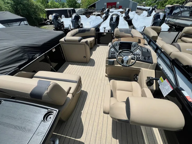 Slide: The Image of 2025 Sylvan L1 DLZ pontoon boat interior with beige seating and modern dashboard. - 4