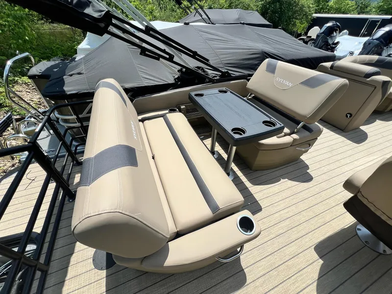Slide: The Image of 2025 Sylvan L1 DLZ boat interior with beige seating and black table. - 40