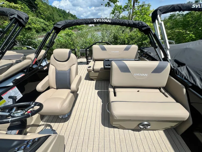 Slide: The Image of 2025 Sylvan L1 DLZ pontoon boat interior with beige seating and steering wheel. - 43