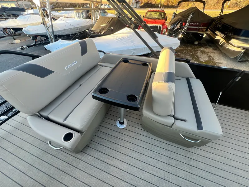 Slide: The Image of 2025 Sylvan L1 DLZ boat interior with beige seating and black table. - 46