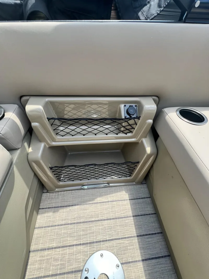 Slide: The Image of 2025 Sylvan L1 DLZ boat interior with storage compartments and cup holder. - 8
