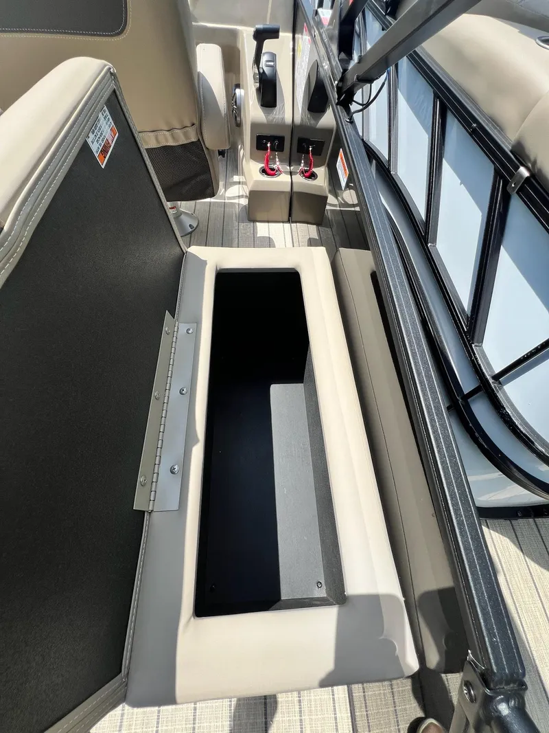 Slide: The Image of 2025 Sylvan L1 DLZ boat interior with open storage compartment and control panel. - 9