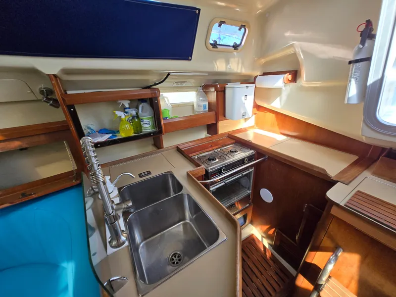 Slide: The Image of Interior of 1994 Hunter 33.5 sailboat kitchen with sink, stove, and storage shelves. - 22